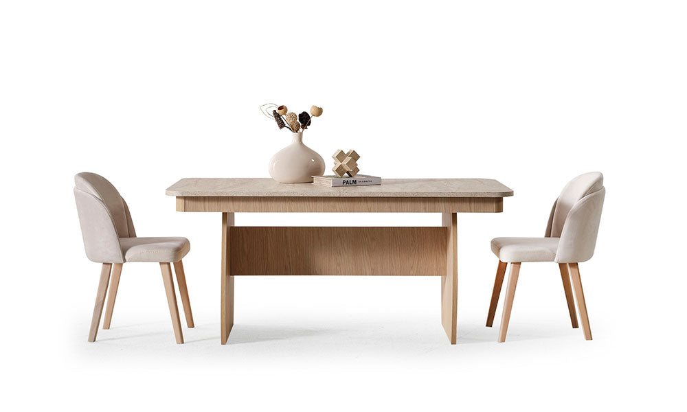 Açık meşe modern yemek masası, krem kumaşlı sandalyeler, taş desenli tabla ve dekoratif vazoyla önden görünüm.