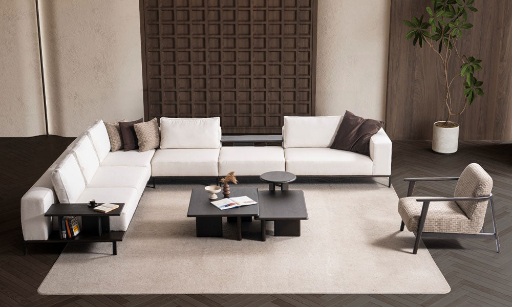 Arinna Modern Köşe Takımı'nın sabit sırtlı beyaz kumaş modülleri, entegre raf ve sehpa detaylarıyla modern salondaki geniş görünümü.