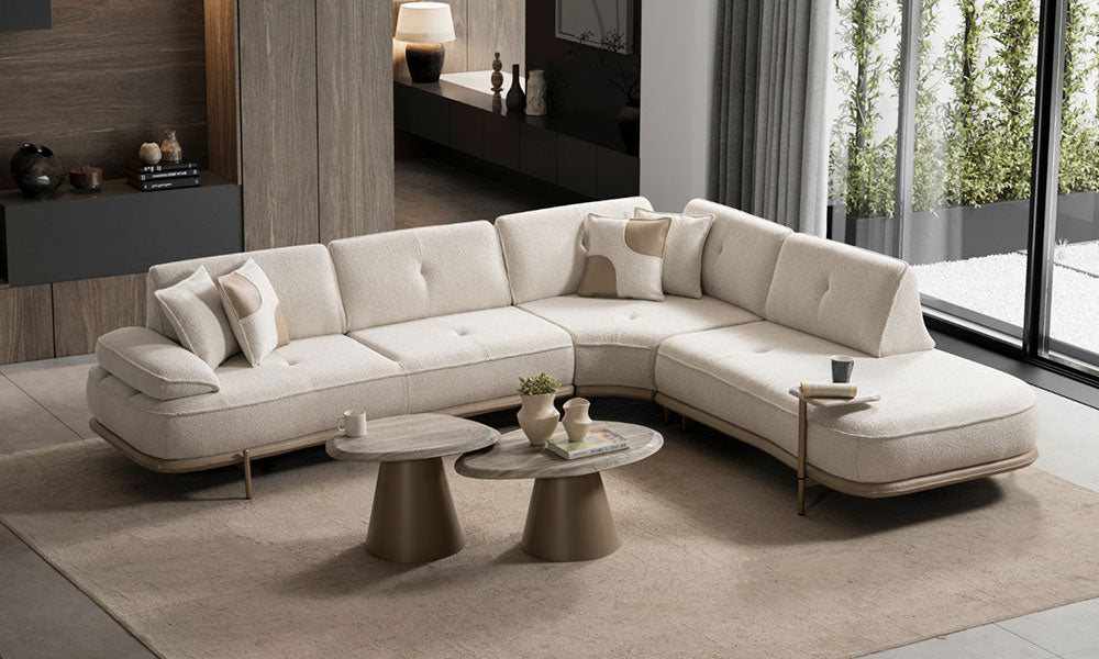 Krem Aura Modern Köşe Koltuk Takımı, geniş L formu, dinlenme modülü, dekoratif kırlentleri ve metal ayaklarıyla modern salonda.