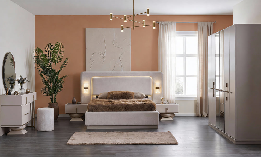 Bonita Modern Yatak Odası Takımı; asimetrik aynalı makyaj şifonyeri, led aydınlatmalı bej kumaş karyola ve heykelsi piramit ayaklı komodinler.