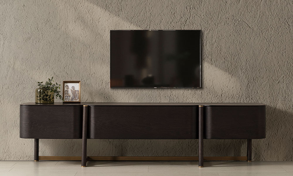 Koyu ceviz renkli Cartier Modern TV Ünitesi, geniş depolama bölmeleri ve gold detaylı yüksek ayaklarıyla önden görünüm