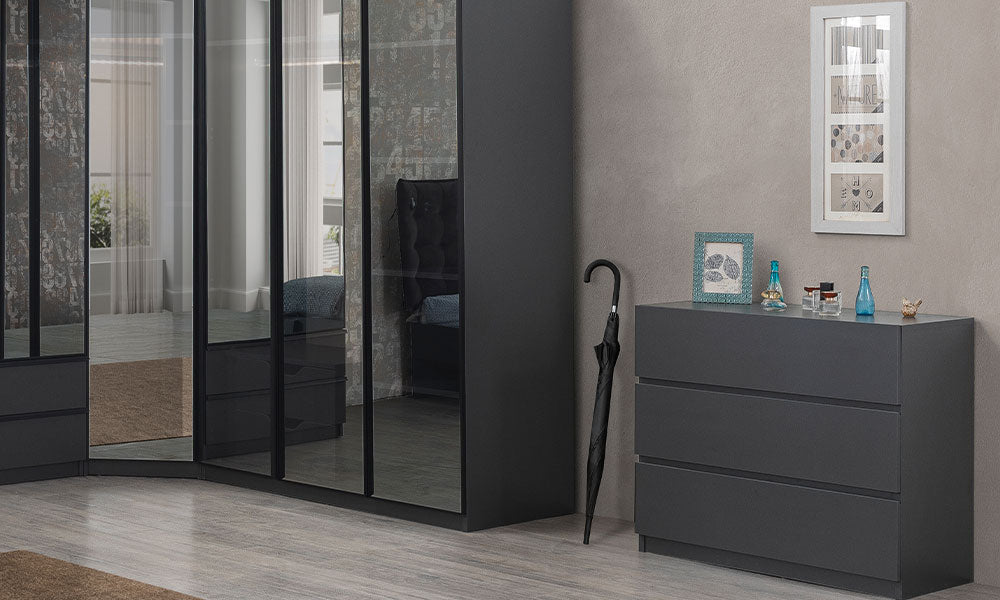 Corner serisinin antrasit renkli, üç geniş çekmeceli, kulpsuz modern şifonyeri ve köşe dolap ile uyumlu görünümü.