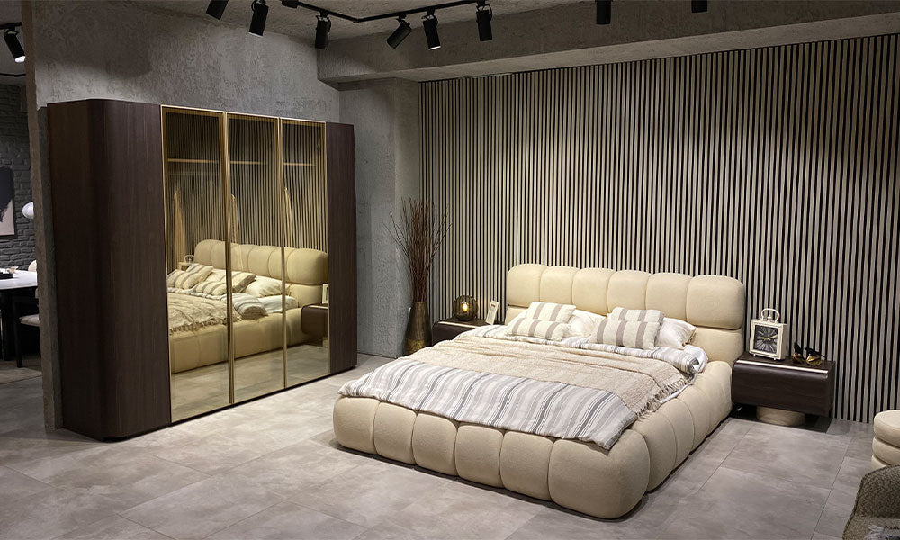 Curve Modern Yatak Odası Takımı, krem döşemeli karyola, bronz aynalı ceviz gardırop ve iki komodinin showroom görünümü