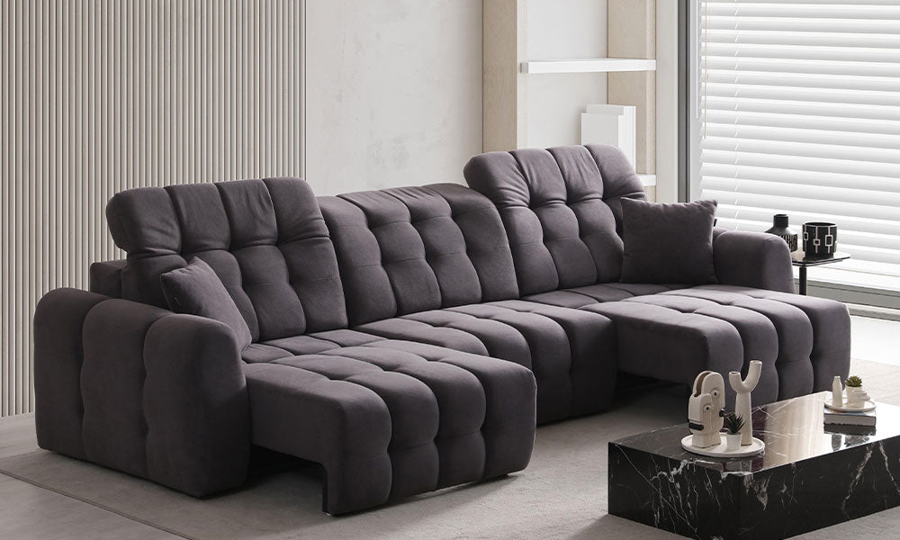 Enzo Modern dörtlü koltuğun motorlu ayak uzatma ve ayarlanabilir başlık mekanizmaları açık haldeyken modern bir salondaki konforlu duruşu.