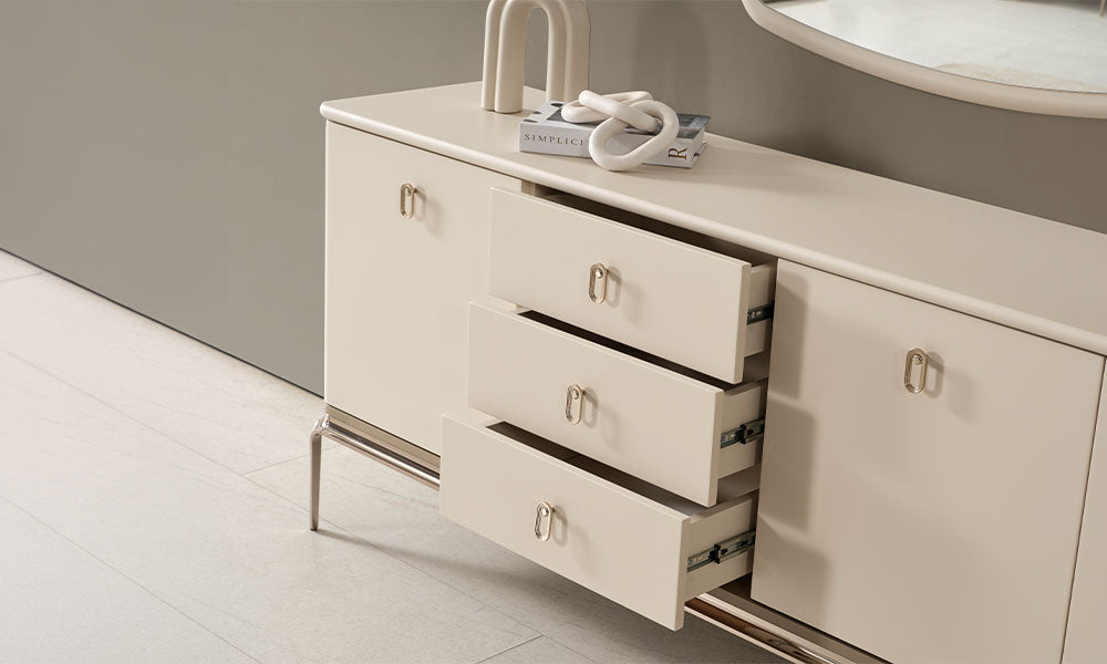 Krem modern konsolun açık durumdaki üç geniş çekmecesi, metal ray sistemi, oval kulpları ve parlak metal alt çerçevesi.