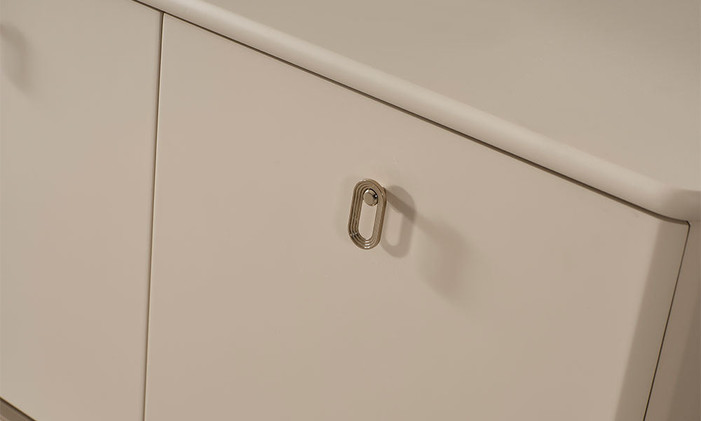 Krem modern konsol kapağında kullanılan oval biçimli parlak metal kulp ve yuvarlatılmış üst tabla detayının yakın görünümü.