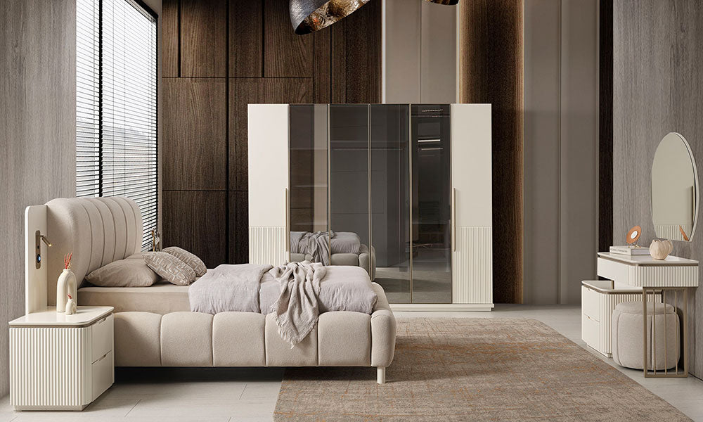 New Golden Modern Yatak Odası Takımı'nın lüks bir yatak odasındaki tam takım görünümü; puf başlıklı kumaş karyola, entegre teknolojik komodinler, bronz cam kapaklı gardırop ve asimetrik şifonyer seti.