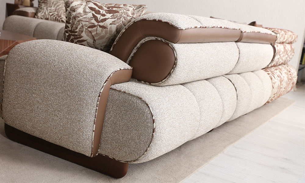 Nois Modern köşe koltuğun kanallı puf dikişli yapısını, dokuma kumaşını ve kontrast deri kolçak detayını gösteren yakın çekim.