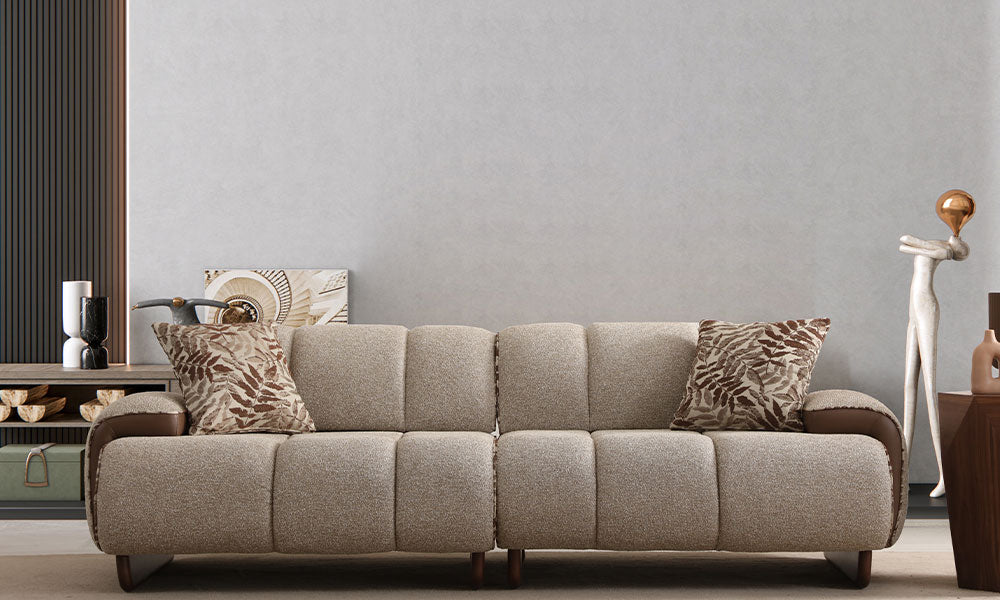 Nois Modern üçlü koltuğun modern bir salondaki önden görünümü; kanallı puf dikişli, dokuma kumaşlı ve deri kolçak detaylı.