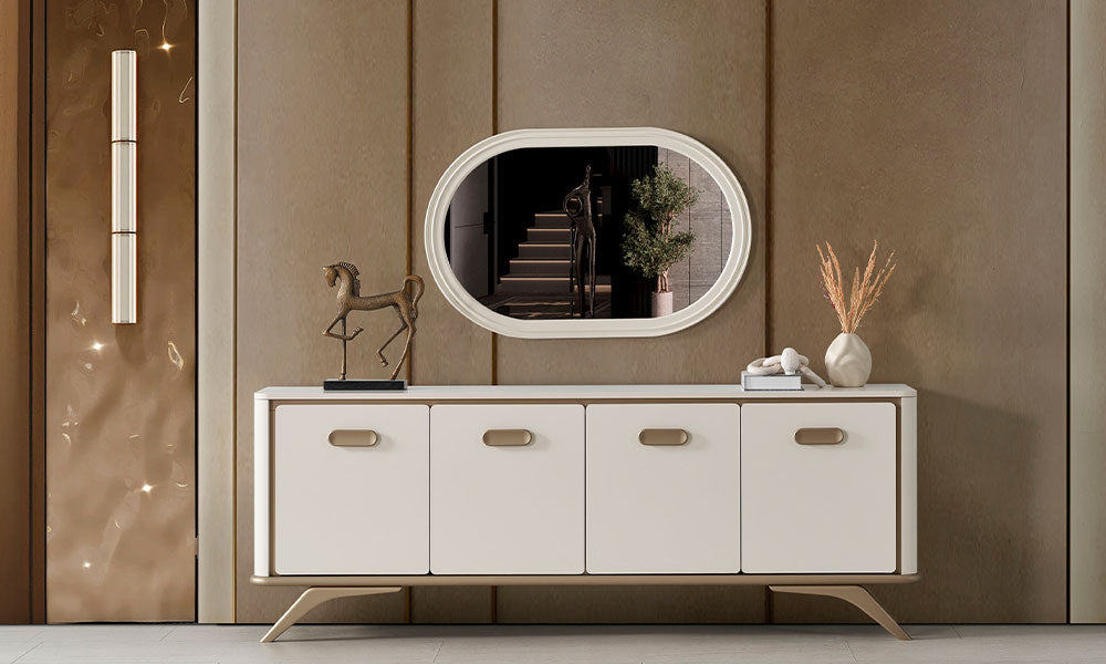 Noya Modern Konsol, krem renkli dört kapaklı gövdesi, bronz kulpları, çapraz metal ayakları ve oval aynasıyla önden görünüm.