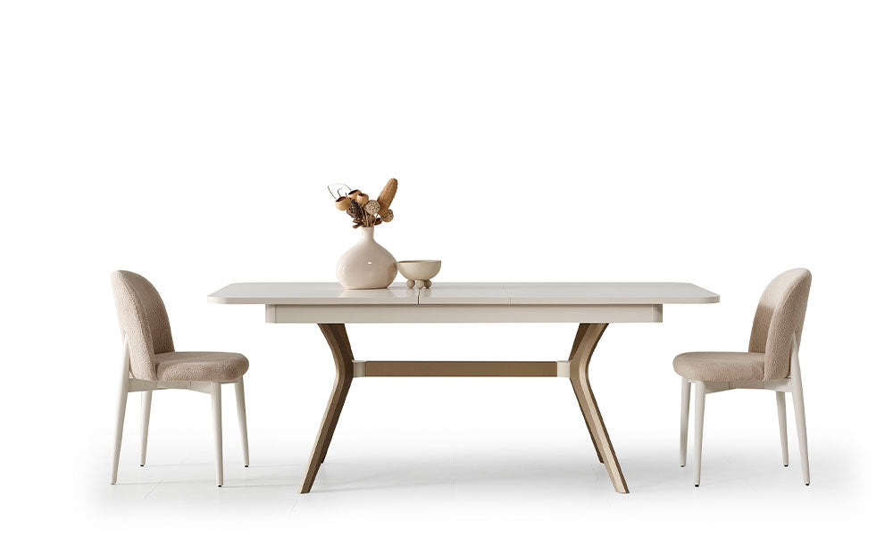 Noya Modern Yemek Masası, krem açılır tabla, iki bej kumaş sandalye, bronz metal ayaklar ve dekoratif vazoyla.