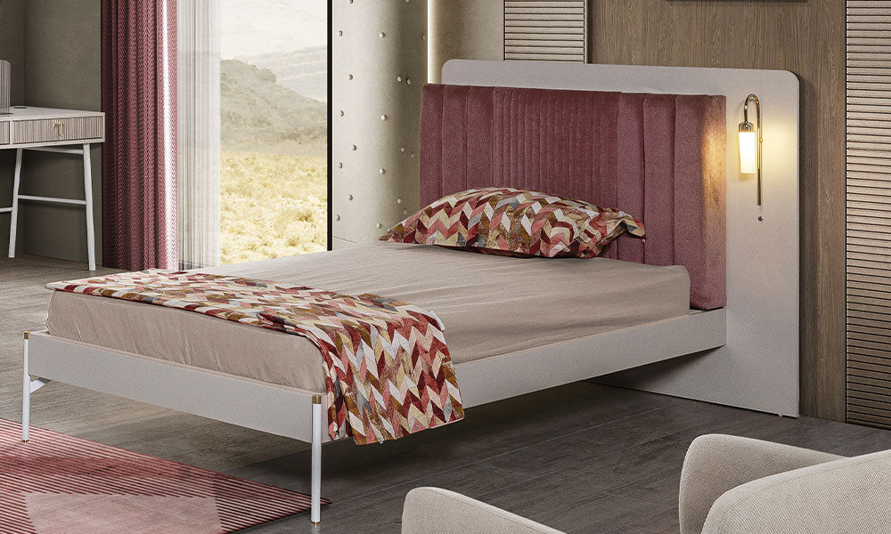 Öykü serisi karyolanın gül kurusu dikey dikişli başlığı, entegre gold okuma lambası, beyaz metal ayakları ve şık yatak tasarımı.