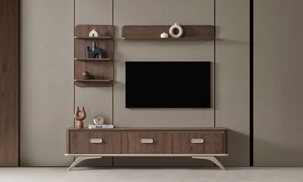 Koyu ceviz renkli Petra modern TV ünitesi, üç çekmeceli alt modülü, krem kulpları, metal ayakları ve ahşap duvar raflarıyla modern salonda.