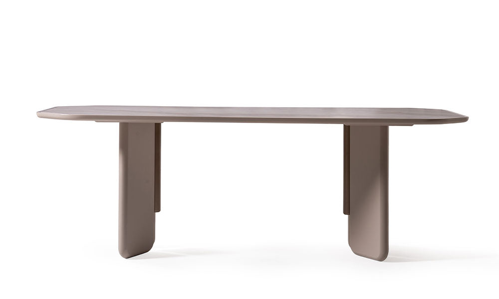 Beyaz arka planda, Sierra Modern yemek masasının düz bej renkli tablası ve mimari panel ayaklı minimalist tasarımının önden görünümü.