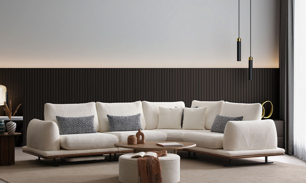 Modern bir salonda, Soho köşe koltuk takımının krem bukle kumaşlı, ahşap bazalı ve metal ayaklı şık duruşu.