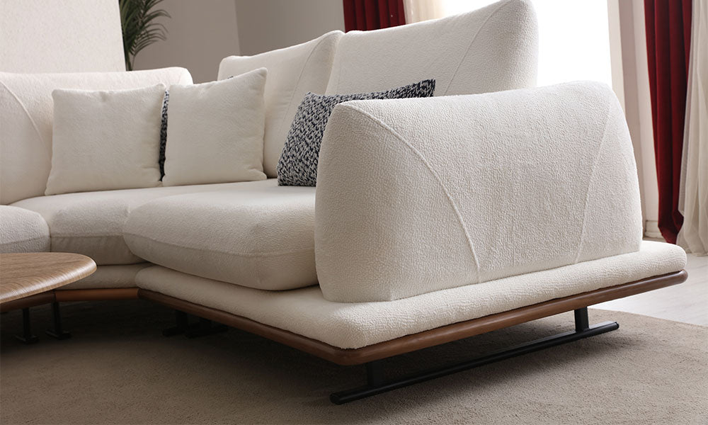 Soho Modern köşe koltuğun zarif kolçak yapısı, bukle kumaş dokusu ve ahşap baza/metal ayak detayının yakın çekimi.