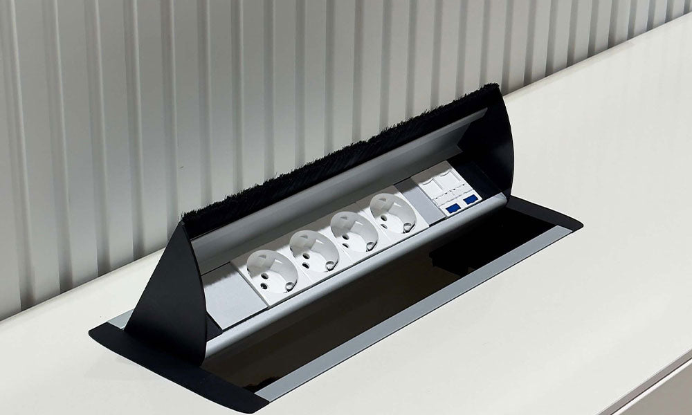 Uçan TV ünitesi konsoluna entegre edilmiş, USB ve priz girişli, açılır (pop-up) gömme priz sisteminin detayı.