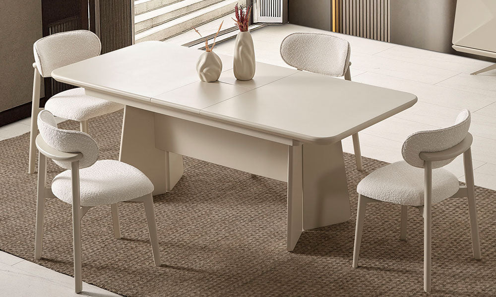 Vakko Modern Yemek Masası'nın bej lake kaplamalı, kapalı haldeki yekpare üst tablası ve bukle kumaş kaplı modern sandalyelerle birlikte lüks salon görünümü.