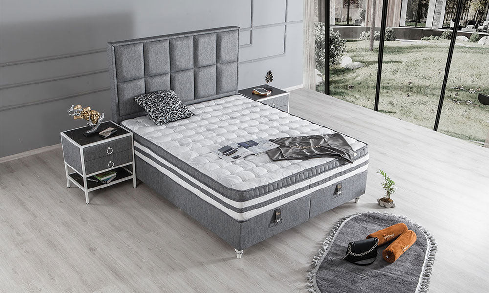 Gri modern karyola ve kare panelli yatak başlığı, beyaz kapitone yatak ve aydınlık yatak odasında üst açıdan görünüm