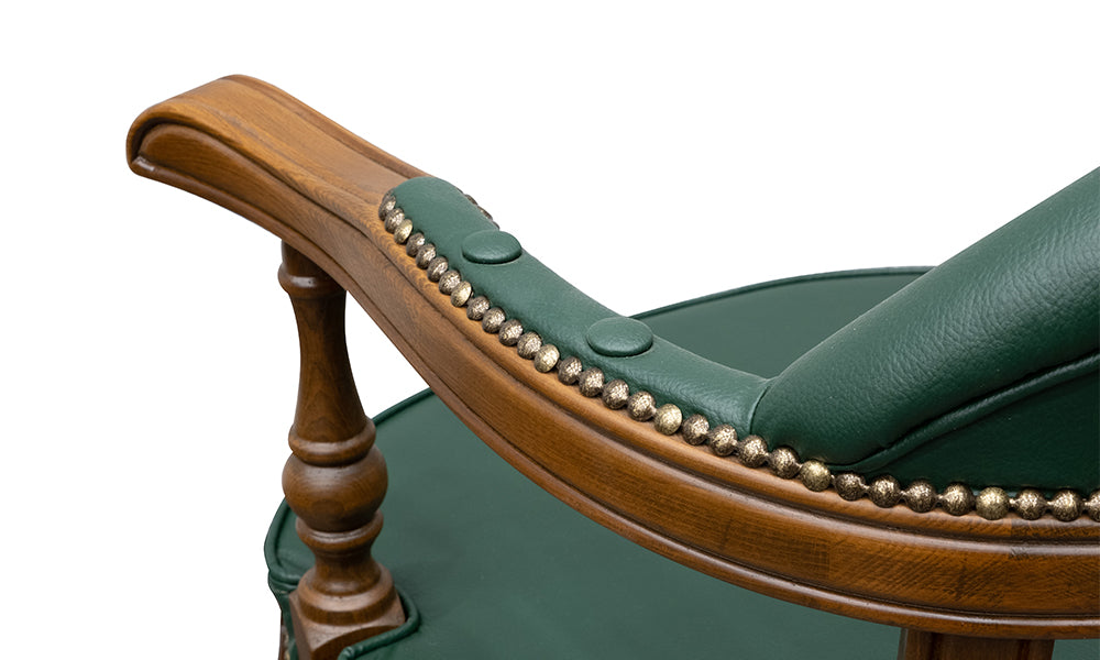 Ahtapot sandalye kolçak detayı; antik pirinç kabara (nailhead) işlemeleri, yeşil deri dokusu ve ceviz rengi ahşap kol desteği.