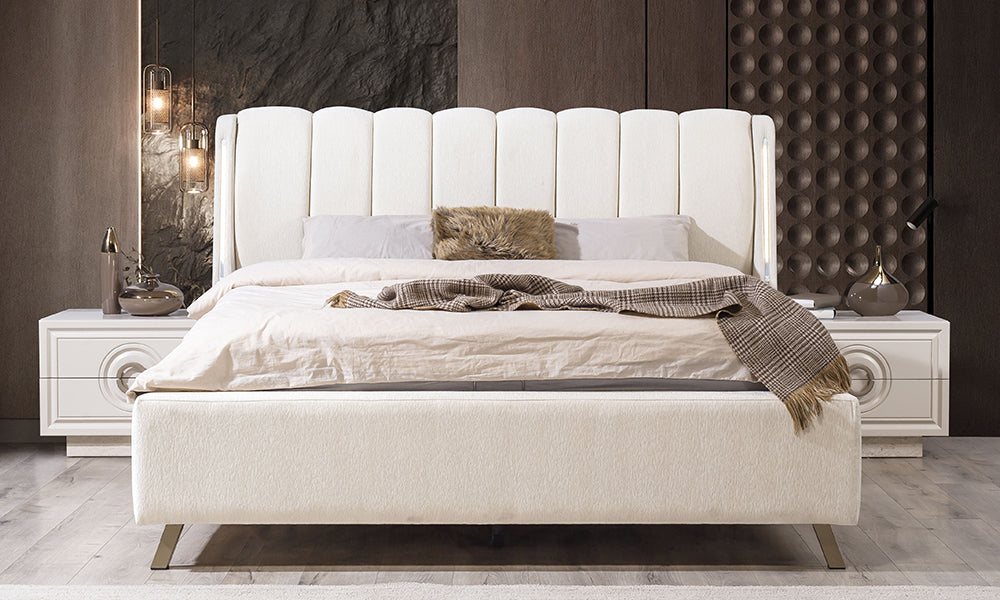 Alkan karyolanın dikey dilimli dolgun başlığı, entegre gece lambası özelliği sunan led barlar ve gold detaylı modern duruşu.