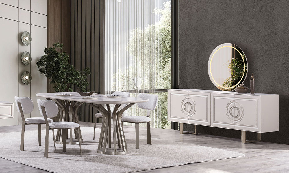 Alkan Modern Yemek Odası Takımı; oval formlu krem yemek masası, heykelsi bronz ayak tasarımı, CNC işlemeli konsol ve ledli yuvarlak ayna dekorasyonu.