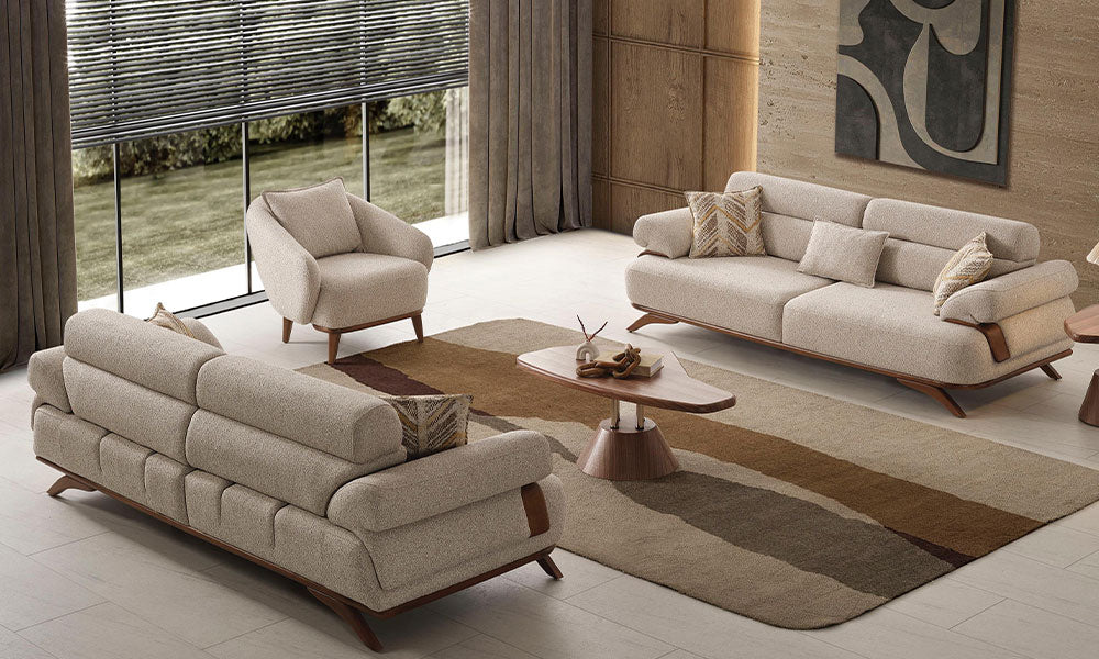 Modern bir salonda, Carle koleksiyonuna ait masif ahşap bazalı üçlü koltuk, ikili koltuk ve berjerin şık yerleşimi.
