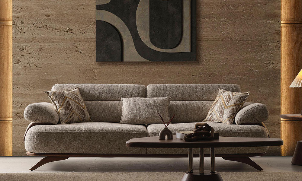 Carle Modern üçlü koltuğun desenli kırlentleriyle birlikte modern bir salondaki şık önden görünümü.
