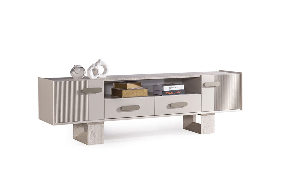Eudora Modern TV Ünitesi; traverten desenli blok ayaklar, dikey fitilli yan kapaklar, iki orta çekmece ve açık raf bölmeli krem tasarım.