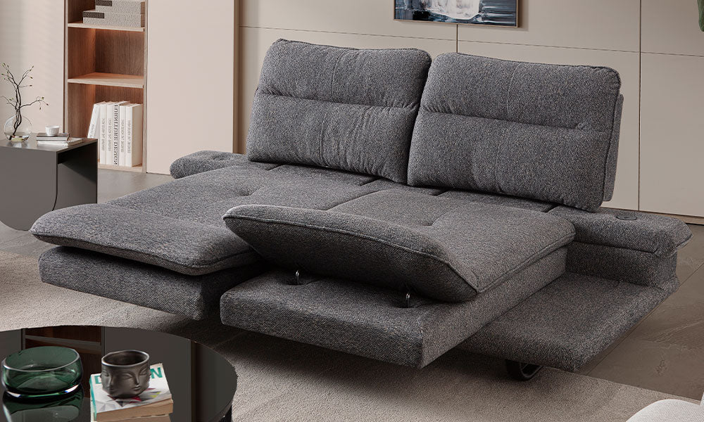 Modern bir salonda, Fiesta üçlü koltuğun motorlu sırt ve ayak mekanizmaları tam açıkken sunduğu geniş uzanma ve dinlenme alanı.