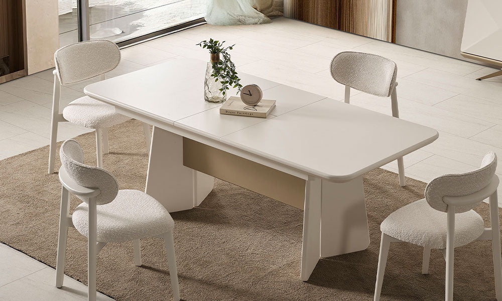 Vakko Modern Yemek Masası'nın parlak bej lake kaplaması ve zarif baza ayağı, bukle kumaşlı sandalyelerle birlikte yemek odası dekorasyonundaki görünümü.