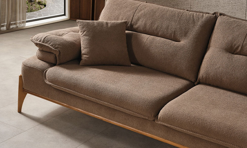 Hayalim Modern üçlü koltuğun kahverengi dokulu kumaşının, kırlentinin ve ahşap baza detayının yakın plan görünümü.