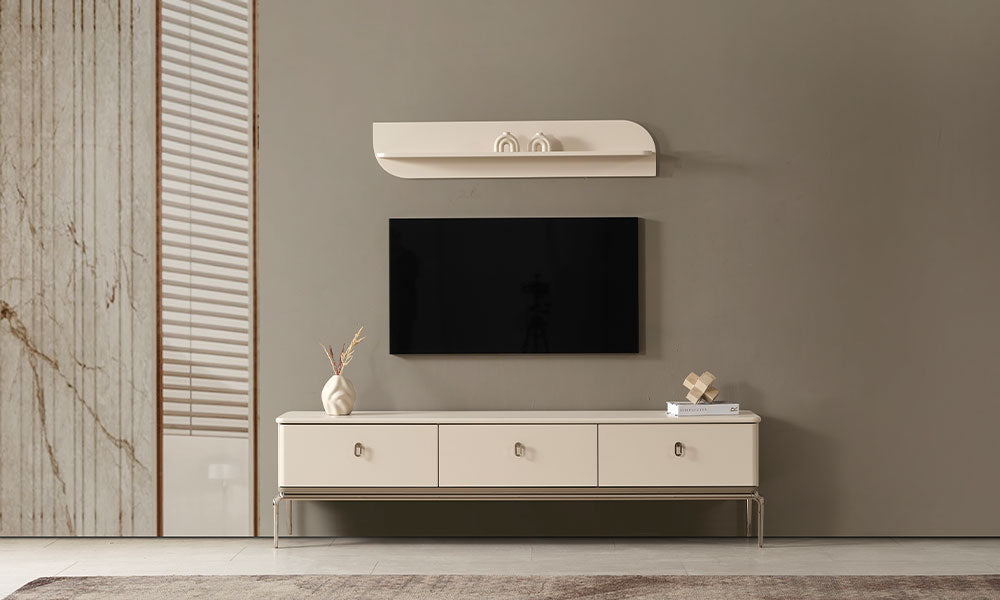 Krem modern TV ünitesi, üç çekmeceli saklama alanı, duvara monte televizyon ve üst duvar rafıyla modern salonda.