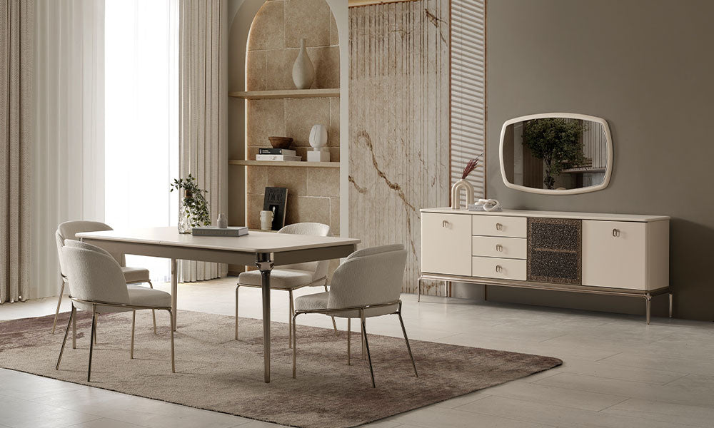 Krem modern yemek odası takımı, parlak metal ayaklı masa, dört sandalye ve dokulu cam detaylı konsolla geniş salon ortamında.