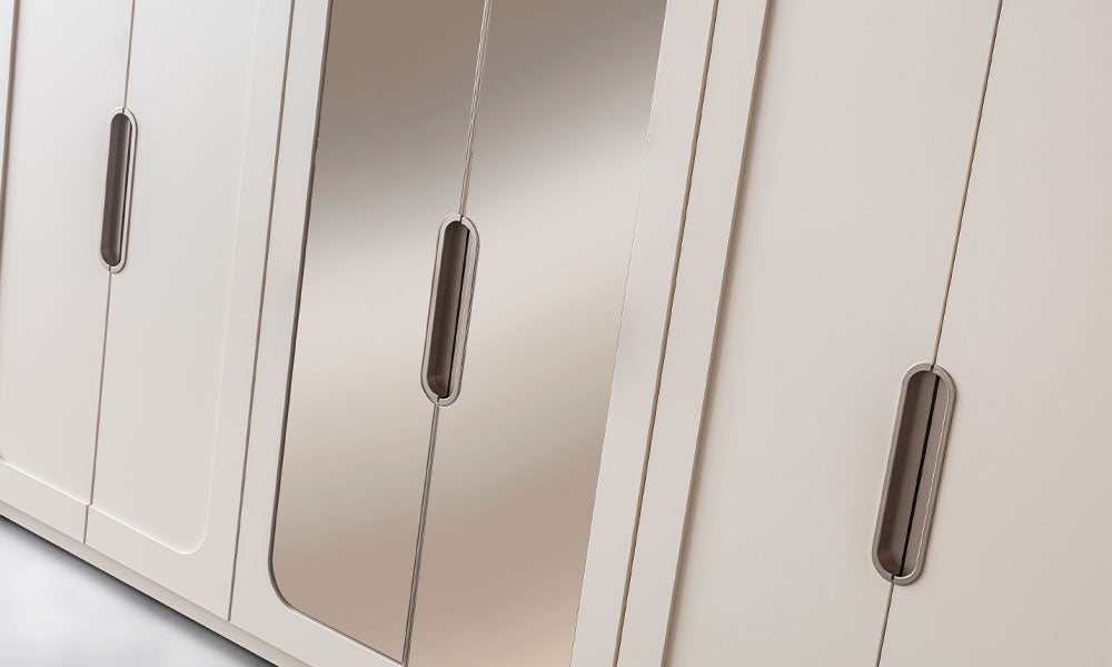 Mabel Modern Gardırop’un aynalı orta kapakları, uzun metal kulpları ve yuvarlatılmış kapak detayları