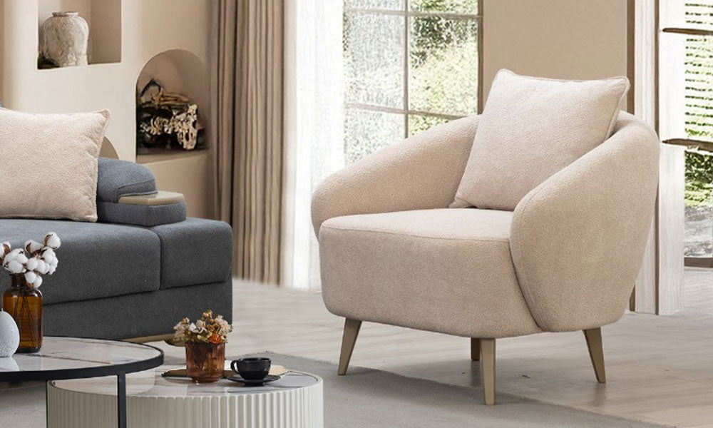 Krem rengi coco kumaş kaplamalı, ahşap ayaklı, oval hatlara sahip Marsilya Modern Berjer.
