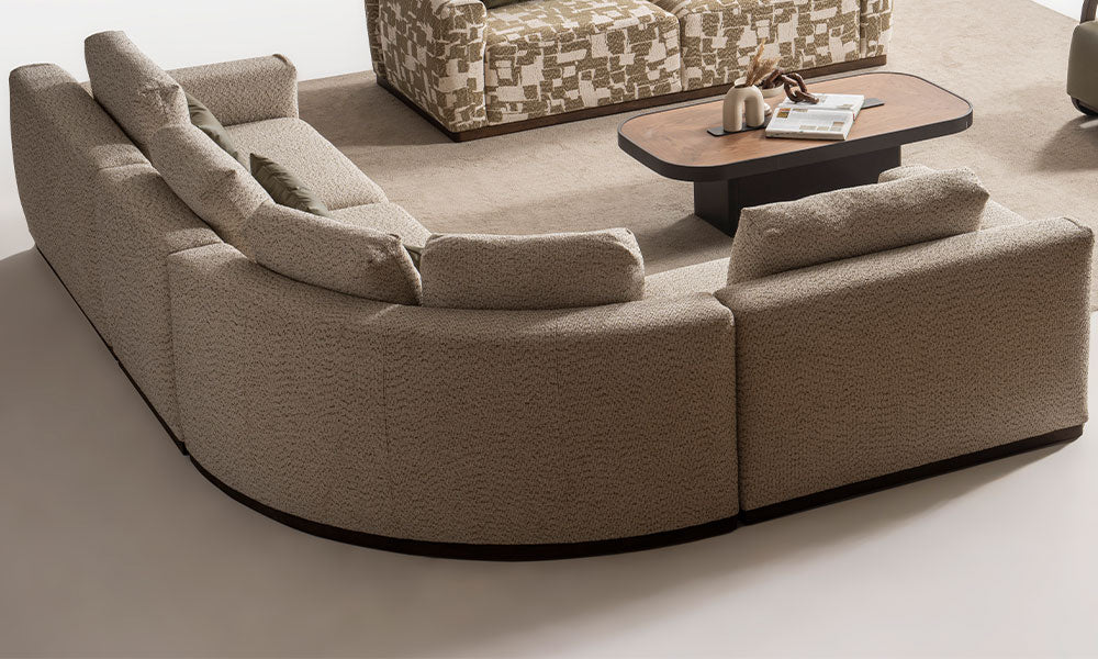 Mengen Modern Köşe Koltuk Takımı'nın arkadan görünümü; kavisli köşe modülü, kalın sırt minderleri ve koyu renk plinth baza detayı.