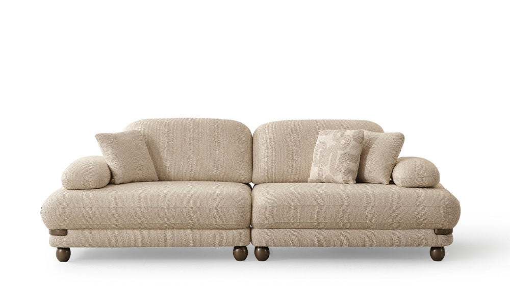 Beyaz arka planda, Mocha Modern üçlü koltuğun desenli kırlentleriyle birlikte, modüler ve simetrik önden görünümü.
