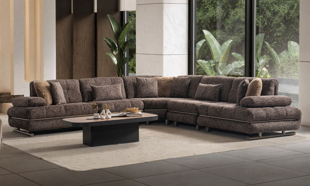 Koyu kahverengi Mono Modern Köşe Koltuk, U biçimli geniş oturum alanı, dekoratif kırlentleri ve metal baza detaylarıyla modern salonda.