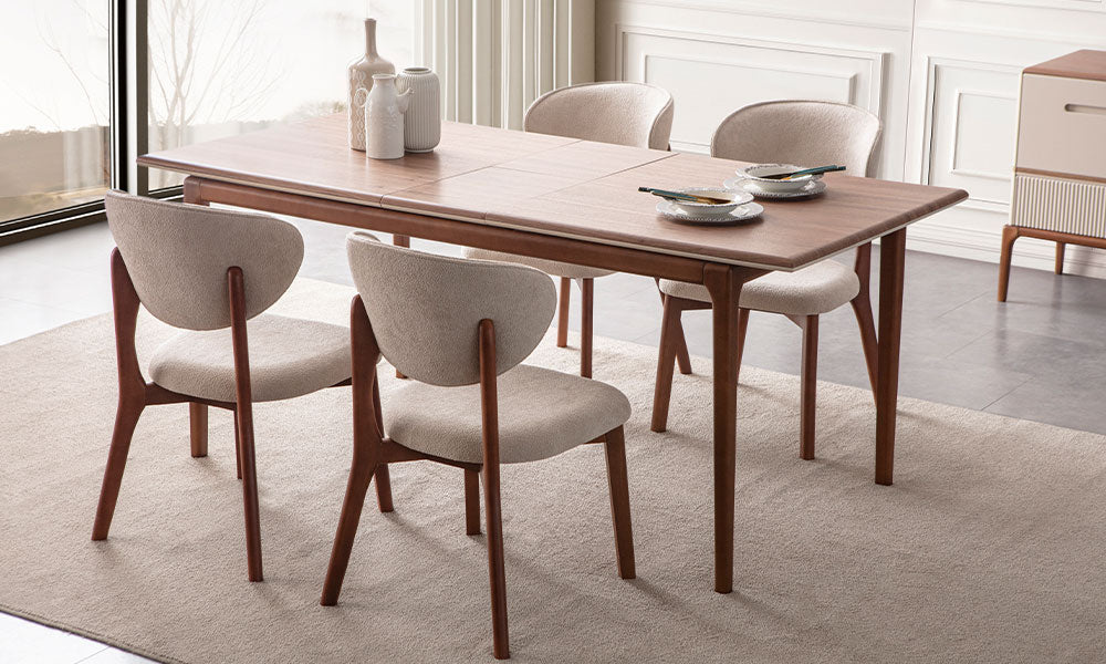 New Rivas yemek masasının ortadan açılır mekanizmasıyla genişletilmiş hali; ceviz yüzey dokusu ve zarif konik ayak yapısının detaylı görünümü.