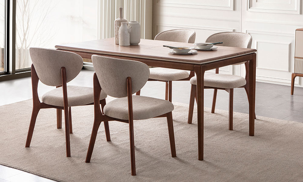 New Rivas Modern Yemek Masası'nın kapalı haldeki ceviz renkli dikdörtgen üst tablası ve yuvarlak hatlı krem sandalyelerle uyumlu duruşu.