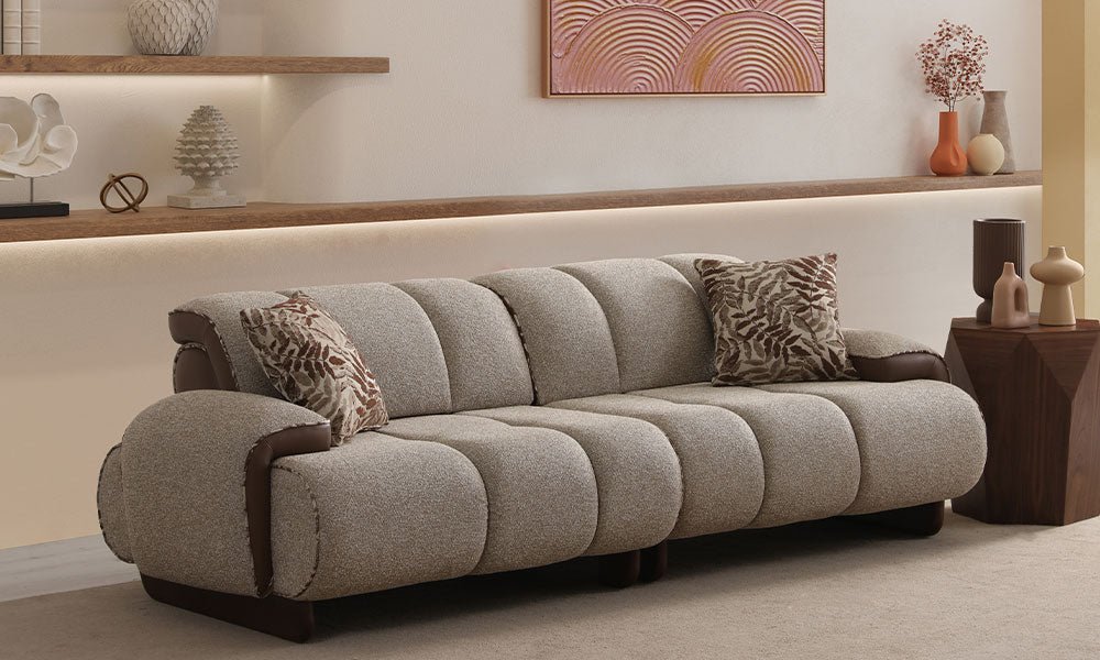 Nois Modern üçlü koltuğun puf formunu, kanallı dikişlerini ve deri/kumaş kontrastını gösteren şık salon görünümü.