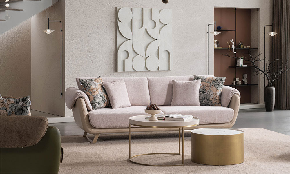 Pudra renkli Olivia modern üçlü koltuk, floral desenli kırlentleri, bej dış gövdesi ve metal ayaklarıyla modern salonda.