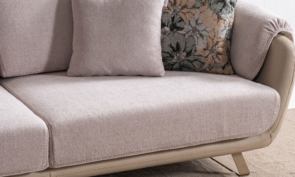 Olivia modern koltuğun pudra kumaşlı geniş oturumu, bej deri görünümlü gövdesi, floral kırlenti ve metal ayağı.
