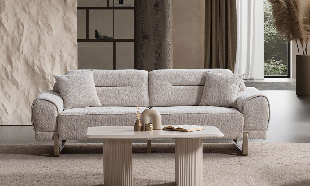 Modern bir salonda, Rüya koleksiyonuna ait bej renkli, kavisli hatlı ve özel tasarım ayaklı üçlü koltuğun önden duruşu.