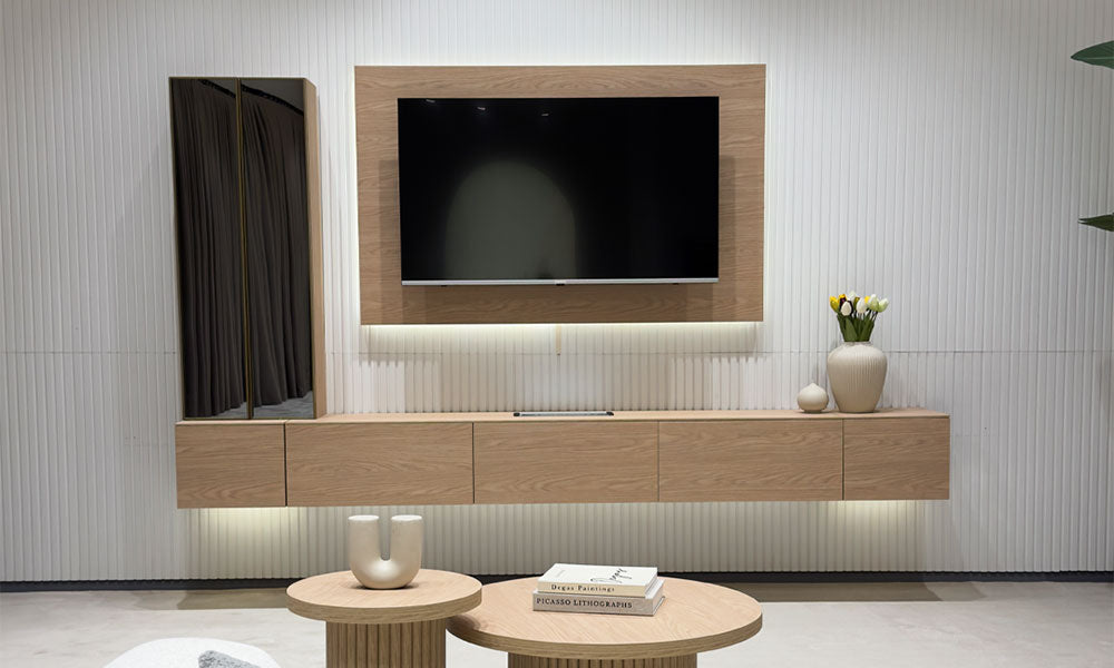 Uçan TV ünitesinin meşe dokulu konsolu, LED aydınlatmalı TV paneli ve füme aynalı dikey modüllerinin önden görünümü.