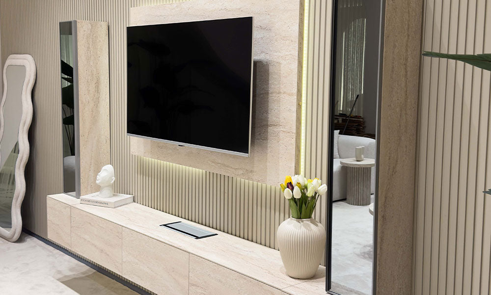 Modern bir salonda, yivli duvar paneli önünde konumlandırılmış, traverten görünümlü ve LED aydınlatmalı Uçan TV Ünitesi takımı.