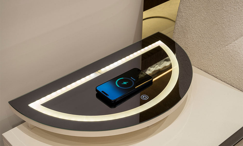 Vena Modern Komodinin üst cam tablasındaki entegre kablosuz şarj alanı ve dokunmatik LED aydınlatma sistemi üzerinde şarj olan telefon.