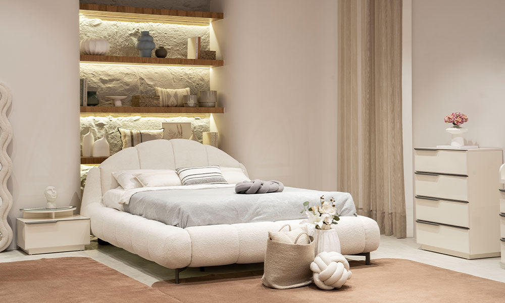 Vena Modern Yatak Odası'nın istiridye başlık tasarımlı bukle karyolası, krem renkli yüksek şifonyeri ve modern aydınlatmalı raf detayları.